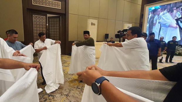 Peserta manasik tengah belajar mengenakan kain ihram.