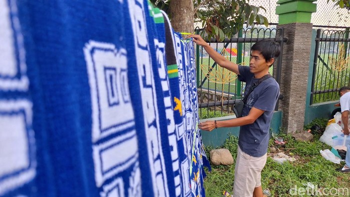 Mukhlis (38) saat menjajakan dagangannya di depan Stadion Si Jalak Harupat. Yuga Hassani/ detikJabar