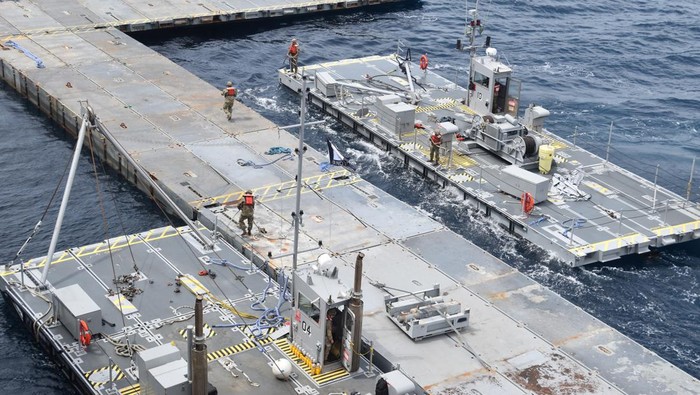U.S. Army Soldiers assigned to the 7th Transportation Brigade (Expeditionary) and U.S. Navy sailors attached to the MV Roy P. Benavidez assemble the Roll-On, Roll-Off Distribution Facility (RRDF), or floating pier, to assist in the delivery of humanitarian aid to the people of Gaza, in the Mediterranean Sea April 26, 2024.   U.S. Army Central/Handout via REUTERS.  THIS IMAGE HAS BEEN SUPPLIED BY A THIRD PARTY