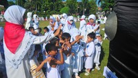 Sejumlah siswa melambaikan tangan saat melintasi batu hajar aswad saat tawaf atau berjalan mengelilingi kabah saat mengikuti pendidikan manasik haji anak di Kudus, Jawa Tengah, Sabtu (18/5/2024).