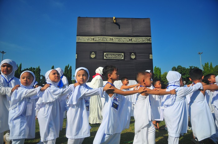 Sejumlah siswa melakukan tawaf atau berjalan mengelilingi kabah sambil berdoa saat mengikuti pendidikan manasik haji anak di Kudus, Jawa Tengah,  Sabtu (18/5/2024). Pendidikan manasik haji yang diikuti 758 siswa itu dalam rangka memperkenalkan tata cara melaksanakan ibadah haji sekaligus menumbuhkan motivasi untuk melakukan ibadah haji kepada anak sejak dini. ANTARA FOTO/Yusuf Nugroho/wpa.