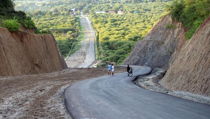 Potret Pembukaan Ruas Jalan Baru di Sigi Sulteng Warga berdiri di ruas jalan yang baru dibuka di Desa Bora, Sigi, Sulawesi Tengah, Jumat (17/5/2024). Pemerintah Provinsi Sulteng membuka ruas jalan sepanjang 22 kilometer yang menghubungkan ibu kota kabupaten itu dengan sejumlah desa menggunakan APBD Sulteng senilai Rp63 miliar untuk memperlancar akses pasar dari kantong-kantong produksi dan distribusi logistik, sekaligus memudahkan warga dalam pelayanan administrasi pemerintahan. ANTARA FOTO/Basri Marzuki/rwa.