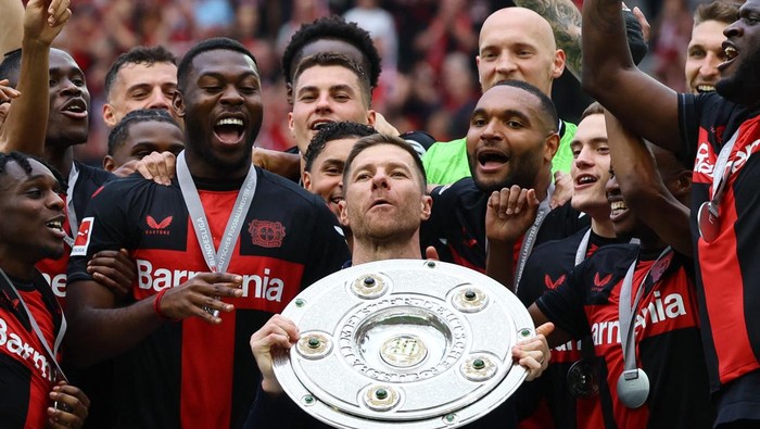 Soccer Football - Bundesliga - Bayer Leverkusen v FC Augsburg - BayArena, Leverkusen, Germany - May 18, 2024 Bayer Leverkusen coach Xabi Alonso celebrates with the trophy after winning the Bundesliga and going unbeaten REUTERS/Wolfgang Rattay DFL REGULATIONS PROHIBIT ANY USE OF PHOTOGRAPHS AS IMAGE SEQUENCES AND/OR QUASI-VIDEO.