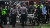Polisi ikut mengevakuasi bangkai pesawat.