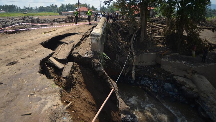 Petugas kepolisian melihat kondisi jembatan yang rusak di Jorong Panti, Nagari Rambatan, Tanah Datar, Sumatera Barat, Minggu (19/5/2024). Jembatan yang diterjang banjir bandang sepekan lalu itu kini terputus dan akses dari Kabupaten Solok terpaksa dialihkan. ANTARA FOTO/Iggoy el Fitra/YU