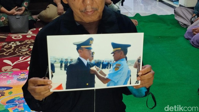 Keluarga menunjukkan foto Pulu Darmawan (kiri) warga Bandungan, Semarang, yang menjadi korban tewas dalam kecelakaan pesawat di BSD, Tangsel, Minggu (19/5/2024).
