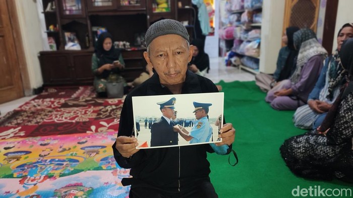 Keluarga menunjukkan foto Pulu Darmawan (kiri) warga Bandungan, Semarang, yang menjadi korban tewas dalam kecelakaan pesawat di BSD, Tangsel, Minggu (19/5/2024).