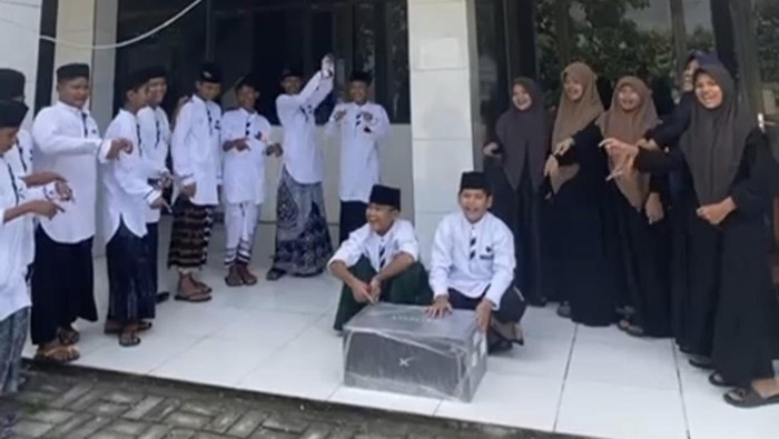 Para siswa SMP di Gresik menunjukkan boks Starlink.