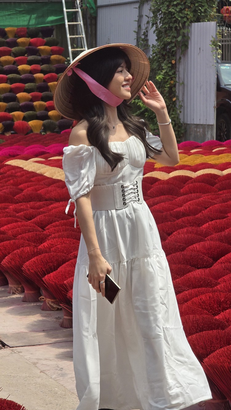 Vonzy Onic tampil cantik dengan gaun putih dan topi caping di Incense Village Vietnam. Pesonanya ditangkap lewat kamera Samsung Galaxy S24.