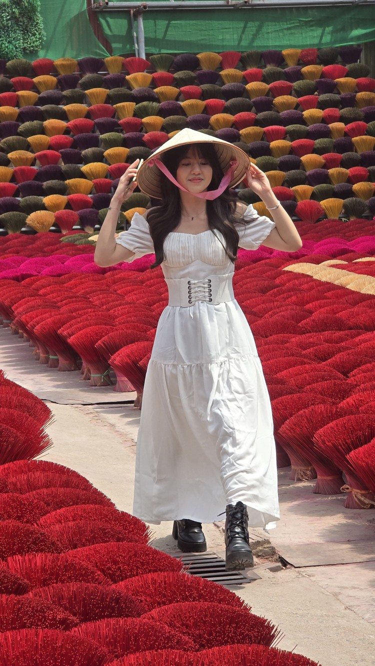 Vonzy Onic tampil cantik dengan gaun putih dan topi caping di Incense Village Vietnam. Pesonanya ditangkap lewat kamera Samsung Galaxy S24.
