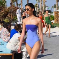 Berbagai baju renang one-piece dalam nuansa merah, beige, dan biru dengan desain menampilkan bahu atau perut ditampilkan para model. Foto: Dok. AFP
