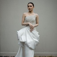 Gaya glamor bak princess kembali jadi pilihan Mahalini untuk resepsi pernikahan di Bali. Hian Tjen menciptakan gaun berwarna putih dengan aksen lipit di pinggang dan bustier penuh hiasan payet dan kristal. Foto: Instagram/@axioo @hiantjen @dhirmanputra