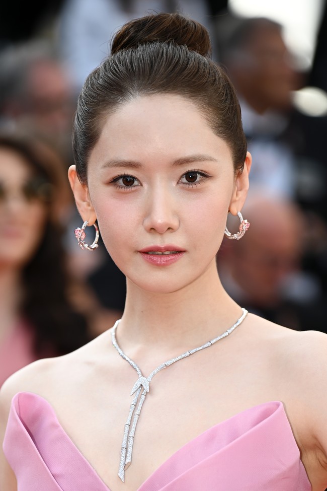 Saat tiba di red carpet Festival Film Cannes 2024, Yoona mengenakan gaun pink rancangan desainer Monique Lhuillier seharga Rp 127,7 juta. Penampilannya semakin elegan dengan tatanan high bun. Foto: Corbis via Getty Images/Stephane Cardinale - Corbis