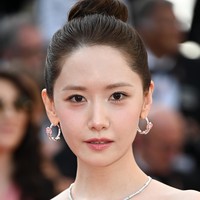 Saat tiba di red carpet Festival Film Cannes 2024, Yoona mengenakan gaun pink rancangan desainer Monique Lhuillier seharga Rp 127,7 juta. Penampilannya semakin elegan dengan tatanan high bun. Foto: Corbis via Getty Images/Stephane Cardinale - Corbis
