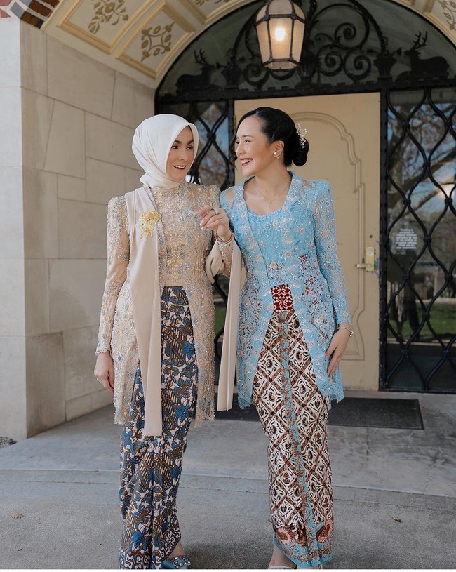 Ibu Beby Tsabina terlihat menakjubkan saat mendampingi wisuda buah hatinya di Western Michigan University, Amerika Serikat. Sang ibu tampil cantik dalam balutan kebaya cream dengan aksen biru muda yang dipadu kain batik. Kebayanya dihiasi payet, kristal serta bordiran berbentuk bunga. Foto: Instagram