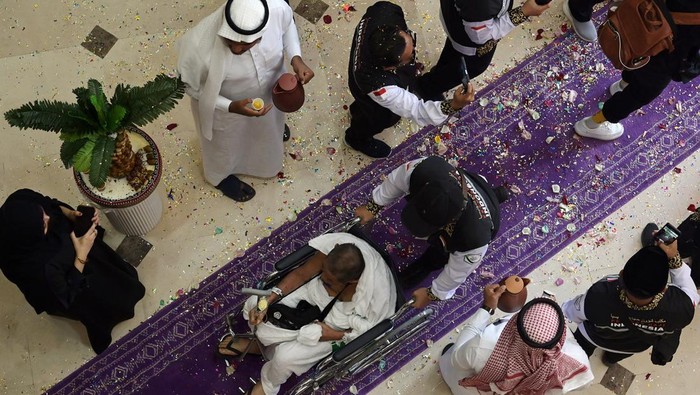 Jamaah calon haji Indonesia memegang bunga dan tangan Petugas Penyelenggara Ibadah Haji (PPIH) saat tiba di hotel, Makkah, Arab Saudi, Senin (20/5/2024). Kementerian Agama menyatakan sebanyak 3.425 jamaah calon haji Indonesia yang tergabung dalam 8 kelompok terbang (kloter) pertama diberangkatkan secara bertahap dari Madinah ke Makkah dengan menggunakan bus pada 20 Mei 2024. ANTARA FOTO/Sigid Kurniawan/rwa.