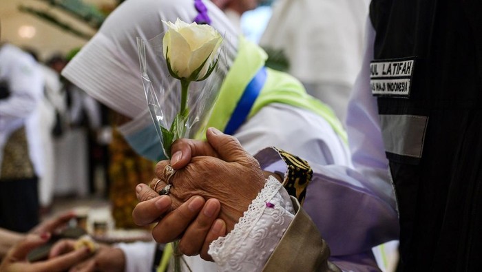 Jamaah calon haji Indonesia memegang bunga dan tangan Petugas Penyelenggara Ibadah Haji (PPIH) saat tiba di hotel, Makkah, Arab Saudi, Senin (20/5/2024). Kementerian Agama menyatakan sebanyak 3.425 jamaah calon haji Indonesia yang tergabung dalam 8 kelompok terbang (kloter) pertama diberangkatkan secara bertahap dari Madinah ke Makkah dengan menggunakan bus pada 20 Mei 2024. ANTARA FOTO/Sigid Kurniawan/rwa.