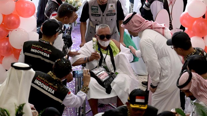 Jamaah calon haji Indonesia memegang bunga dan tangan Petugas Penyelenggara Ibadah Haji (PPIH) saat tiba di hotel, Makkah, Arab Saudi, Senin (20/5/2024). Kementerian Agama menyatakan sebanyak 3.425 jamaah calon haji Indonesia yang tergabung dalam 8 kelompok terbang (kloter) pertama diberangkatkan secara bertahap dari Madinah ke Makkah dengan menggunakan bus pada 20 Mei 2024. ANTARA FOTO/Sigid Kurniawan/rwa.