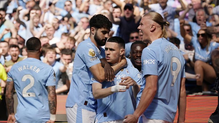 Manchester Citys Phil Foden, center, celebrates with his teammates after scoring his sides opening goal during the English Premier League soccer match between Manchester City and West Ham United at the Etihad Stadium in Manchester, England, Sunday, May 19, 2024. (AP Photo/Dave Thompson)