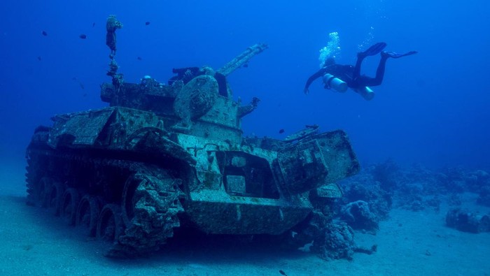 A diver swims next to a submerged military vehicle at the Underwater Military Museum in Aqaba, Jordan, May 7, 2024. REUTERS/Stelios Misinas