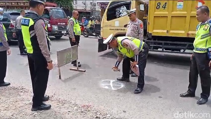 Polisi melakukan olah TKP laka lantas yang menewaskan pemotor di Palembang.