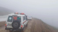 Barisan kendaraan tanggap darurat siaga di lokasi yang berkabut.