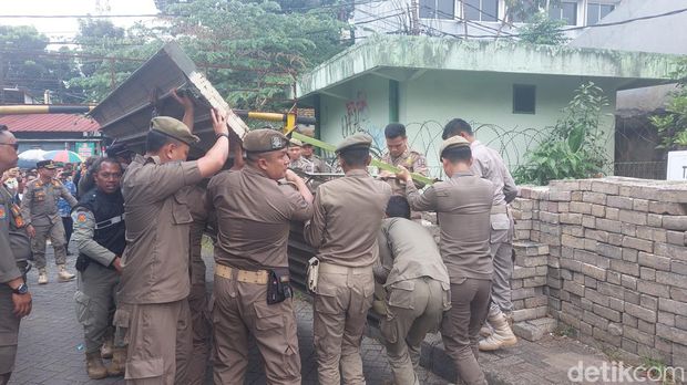 Satpol PP Kota Bogor membuka akses jalan warga menuju Pasar Jambu Dua yang sempat ditutup pihak pengelola mal. (M Sholihin/detikcom)