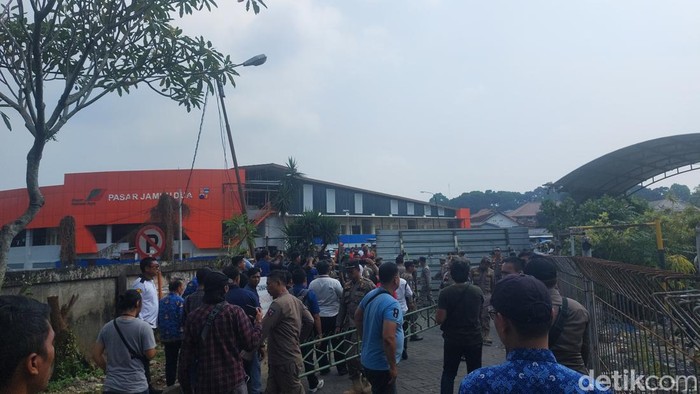 Satpol PP Kota Bogor membuka akses jalan warga menuju Pasar Jambu Dua yang sempat ditutup pihak pengelola mal. (M Sholihin/detikcom)