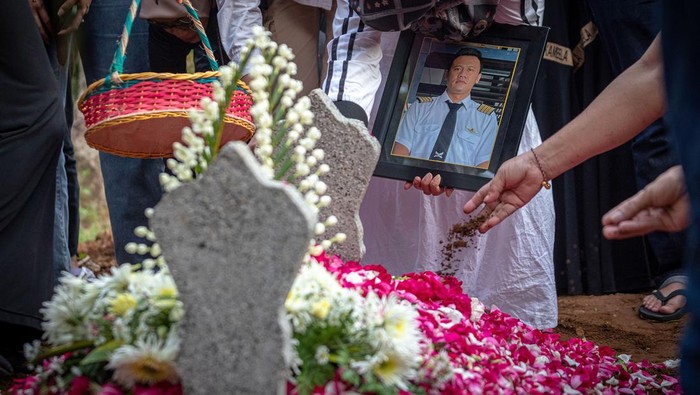 Suasana Pemakaman Pilot Pesawat Jatuh di BSD Ayah dan ibu almarhum Kapten Pilot Pulu Darmawan, Mahyanto (ketiga kiri) dan Yuliati (kedua kanan) menyaksikan pusara anaknya seusai prosesi pemakaman di TPU Desa Duren, Kecamatan Bandungan, Kabupaten Semarang, Jawa Tengah, Senin (20/5/2024). Pulu (38) yang merupakan instruktur penerbang tersebut merupakan salah satu dari tiga korban jiwa jatuhnya pesawat latih Tecnam P2006T PK-IFP di Lapangan Sunburst, BSD, Tangerang Selatan, Banten pada Minggu (19/5). ANTARA FOTO/Aji Styawan/rwa.