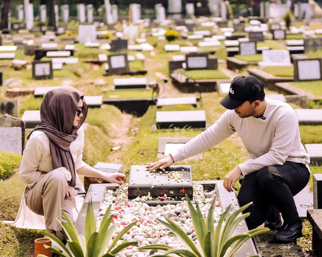 Thariq dan Aaliyah tampil kompak mengenakan pakaian berwarna krem. Aaliyah sendiri terlihat melengkapi penampilannya dengan kerudung berwarna coklat. Keduanya pun berdoa dengan khusyuk di makam almarhum Adjie Massaid. Foto: Instagram/@thariqhalilintar