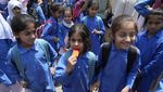 Siswa di Pakistan Ngemil Es Serut Ditengah Panasnya Cuaca