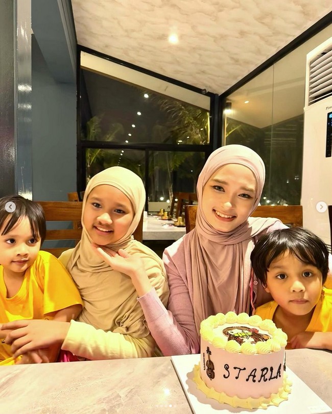 Melalui akun Instagram Story, Inara Rusli mengunggah video sedang merayakan ulang tahun anaknya, Starla Rhea Idola Virgoun di Pantai Indak Kapuk (PIK). Inara mengenakan hijab pashmina instan warna pastel pink. Sedangkan Starla memakai hijab pashmina jersey warna nude. Foto: Dok. Instagram @mommy_starla.