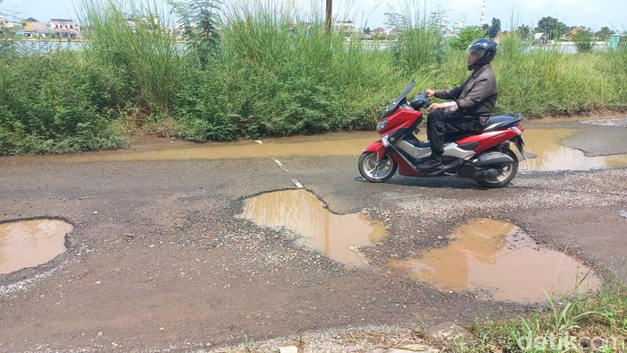 Warga Opi Jakabaring mengeluh soal jalan berlubang di kawasan Danau Opi Jakabaring. Jalan berlubang ini kini digenangi air sehingga menghambat keluar masuknya kendaraan.