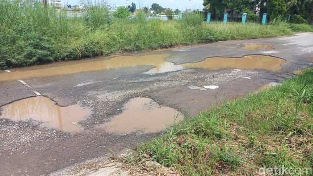 Warga Opi Jakabaring mengeluh soal jalan berlubang di kawasan Danau Opi Jakabaring. Jalan berlubang ini kini digenangi air sehingga menghambat keluar masuknya kendaraan.