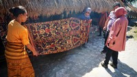 Risma memperhatikan pola dan paduan warna serta kerapian dari tenun ikat tradisional di Kampung Adat Praiijing, Desa Tebara Sumba Barat. Mensos Risma meyakini kain tenun ikat ini, merupakan salah satu yang terbaik dan sanggup bersaing dengan produk-produk Amerika Tengah maupun Amerika Selatan.