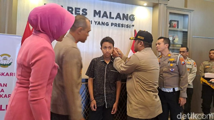 Kapolres Malang AKBP Putu Kholis Aryana saat memberikan bantuan alat bantu dengar