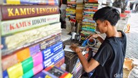 Seorang pedagang buku di Kampung Ilmu Surabaya sedang melakukan pengemasan pesanan buku yang akan dikirim melalui ekspedisi. Mereka banyak beralih memasarkan buku melalui online shop.