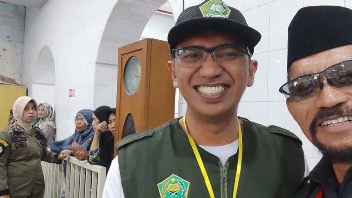Panitia penerimaan haji Yohannes Salu Tandi (peci hitam) saat melaksanakan tugas.