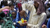 Cuaca panas membuat es serut laris manis diserbu anak-anak. AP Photo/KM Chaudary.