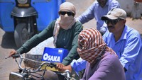 Ada juga pemotor yang menjadikan syal untuk melindungi kepada dan wajahnya dari sinar matahari. AP Photo/Pervez Masih.