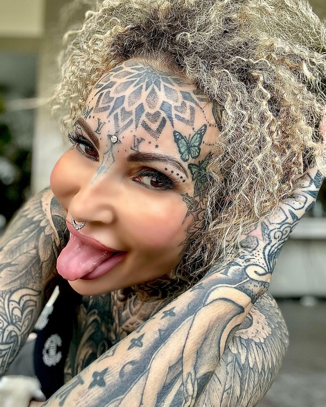 Adrianna Eisenbach adalah wanita yang punya banyak tato yang menghiasi hampir semua bagian tubuh, termasuk wajahnya. Ia bahkan menghiasi dahinya dengan dua logo Louis Vuitton di atas alisnya.  Foto: Instagram Adrianna Eisenbach