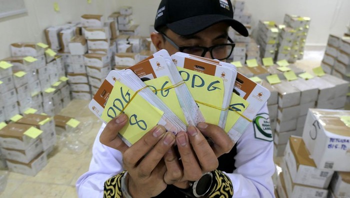 Petugas Penyelenggara Ibadah Haji (PPIH) bagian Media Center Haji membantu mengelompokkan kartu pintar atau smart card jamaah calon haji Indonesia di Makkah, Arab Saudi, Selasa (21/5/2024). PPIH Arab Saudi mulai mendistribusikan kartu pintar lewat perwakilan kloter masing-masing secara bertahab kepada jamaah calon haji Indonesia sebagai akses mengikuti rangkaian ibadah di Arafah, Muzdalifah, dan Mina (Armuzna). ANTARA FOTO/Sigid Kurniawan/foc.