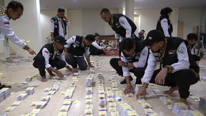 Petugas Penyelenggara Ibadah Haji (PPIH) bagian Media Center Haji membantu mengelompokkan kartu pintar atau smart card jamaah calon haji Indonesia di Makkah, Arab Saudi, Selasa (21/5/2024). PPIH Arab Saudi mulai mendistribusikan kartu pintar lewat perwakilan kloter masing-masing secara bertahab kepada jamaah calon haji Indonesia sebagai akses mengikuti rangkaian ibadah di Arafah, Muzdalifah, dan Mina (Armuzna). ANTARA FOTO/Sigid Kurniawan/foc.