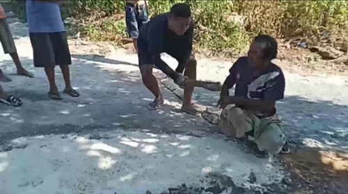 Pegawai Disdukcapil Kota Kupang, NTT, Adi Nurukapi, saat memukul Lukas Nitbani dengan balok. (Tangkapan layar video viral)