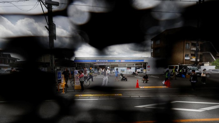 Penampakan Kain Hitam Penghalang Pemandangan Gunung Fuji yang Viral Workers erect a barrier to block the view of a popular Mount Fuji photo spot, near a convenience store in Fujikawaguchiko town, Yamanashi prefecture, Japan, May 21, 2024. REUTERS/Kim Kyung-Hoon