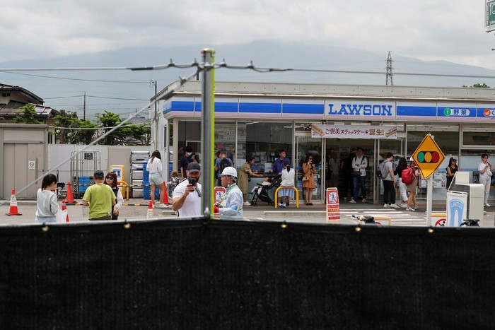 Workers erect a barrier to block the view of a popular Mount Fuji photo spot, near a convenience store in Fujikawaguchiko town, Yamanashi prefecture, Japan, May 21, 2024.   REUTERS/Kim Kyung-Hoon