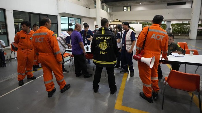 Members of a rescue team discuss after a London-Singapore flight was diverted to Bangkok due to severe turbulence, in Bangkok, Thailand, Tuesday, May 21, 2024. The plane apparently plummeted for a number of minutes before it was diverted to Bangkok, where emergency crews rushed to help injured passengers amid stormy weather, Singapore Airlines said Tuesday. (AP Photo/Sakchai Lalit)