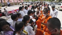 Biksu Buddha berjubah kuning antre untuk menerima sedekah saat peringati Visak Bochea Buddha di pagoda Praseth Leu di barat laut Phnom Penh, Kamboja, Rabu (22/5/2024).