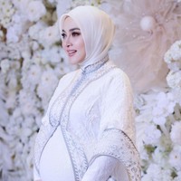 Syahrini tampak mengenakan gamis putih dengan outer lace berhias bordir aksen abu-abu. Jilbabnya ditata dengan gaya simple yang juga bernuansa putih. Foto: instagram Syahrini