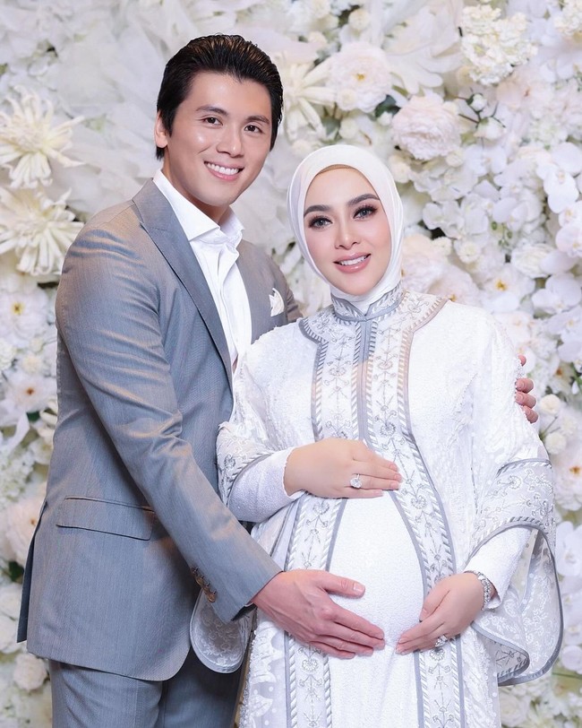 Penampilannya serasi dengan sang suami, Reino Barack, yang memakai setelan jas abu-abu serta kemeja putih. Foto: instagram Syahrini